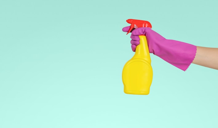 person holding yellow plastic spray bottle