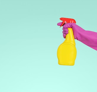 person holding yellow plastic spray bottle