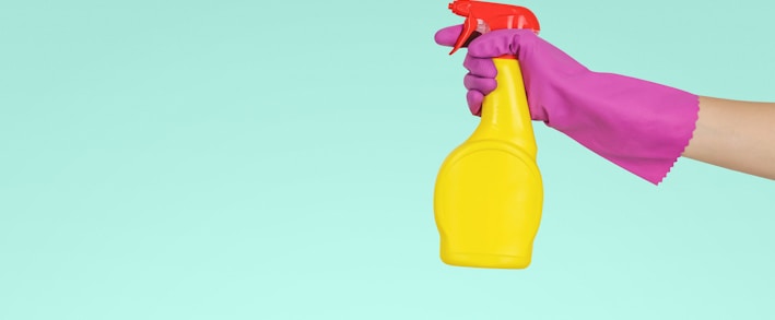 person holding yellow plastic spray bottle