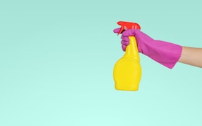 person holding yellow plastic spray bottle