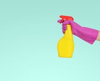 person holding yellow plastic spray bottle