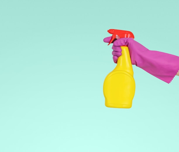 person holding yellow plastic spray bottle