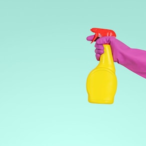 person holding yellow plastic spray bottle