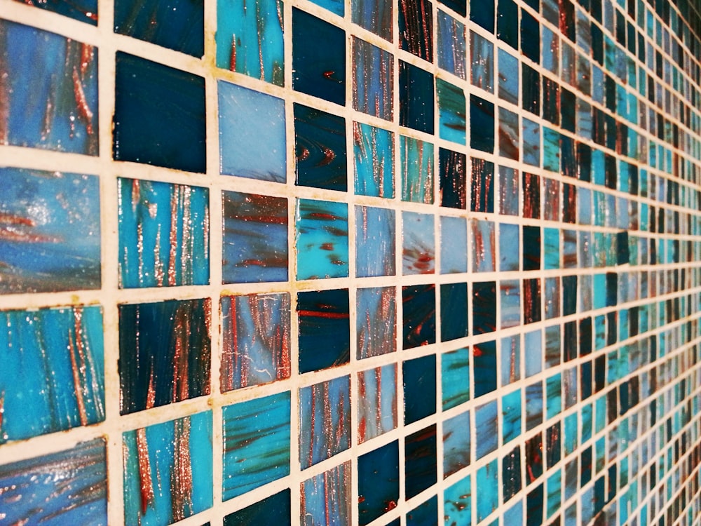 a close up of a tiled wall with blue and red tiles