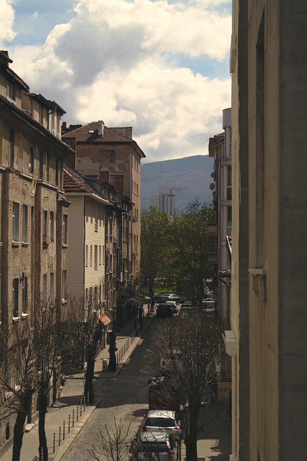 vehicles on road beside brown buildings