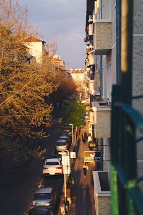 A vibrant urban street scene captured at golden hour, showcasing dynamic shadows and lively colors.
