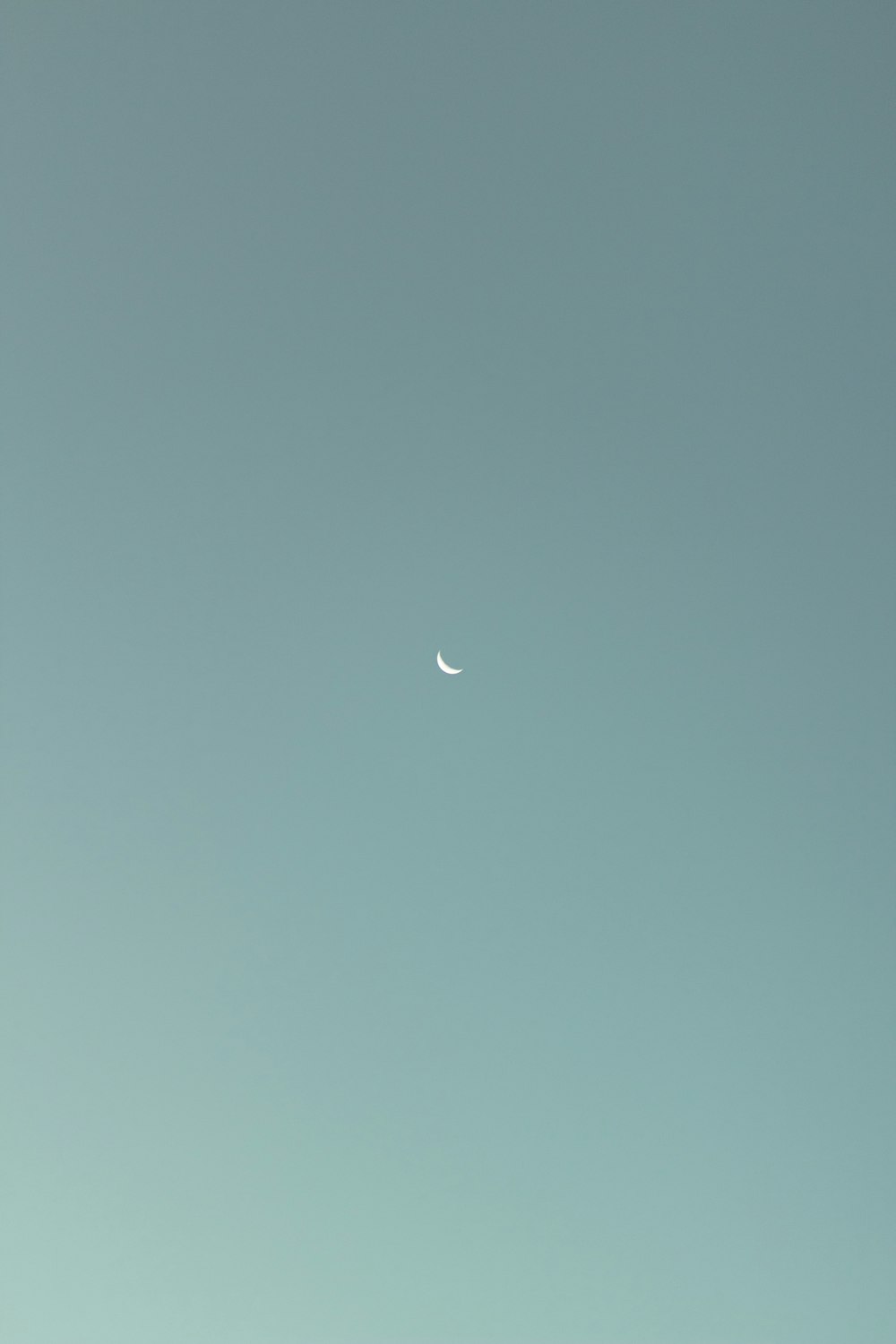 an airplane flying in the sky with a half moon