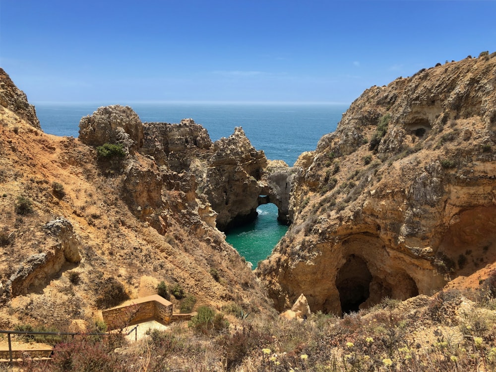 brown cliff near ocean during daytime'