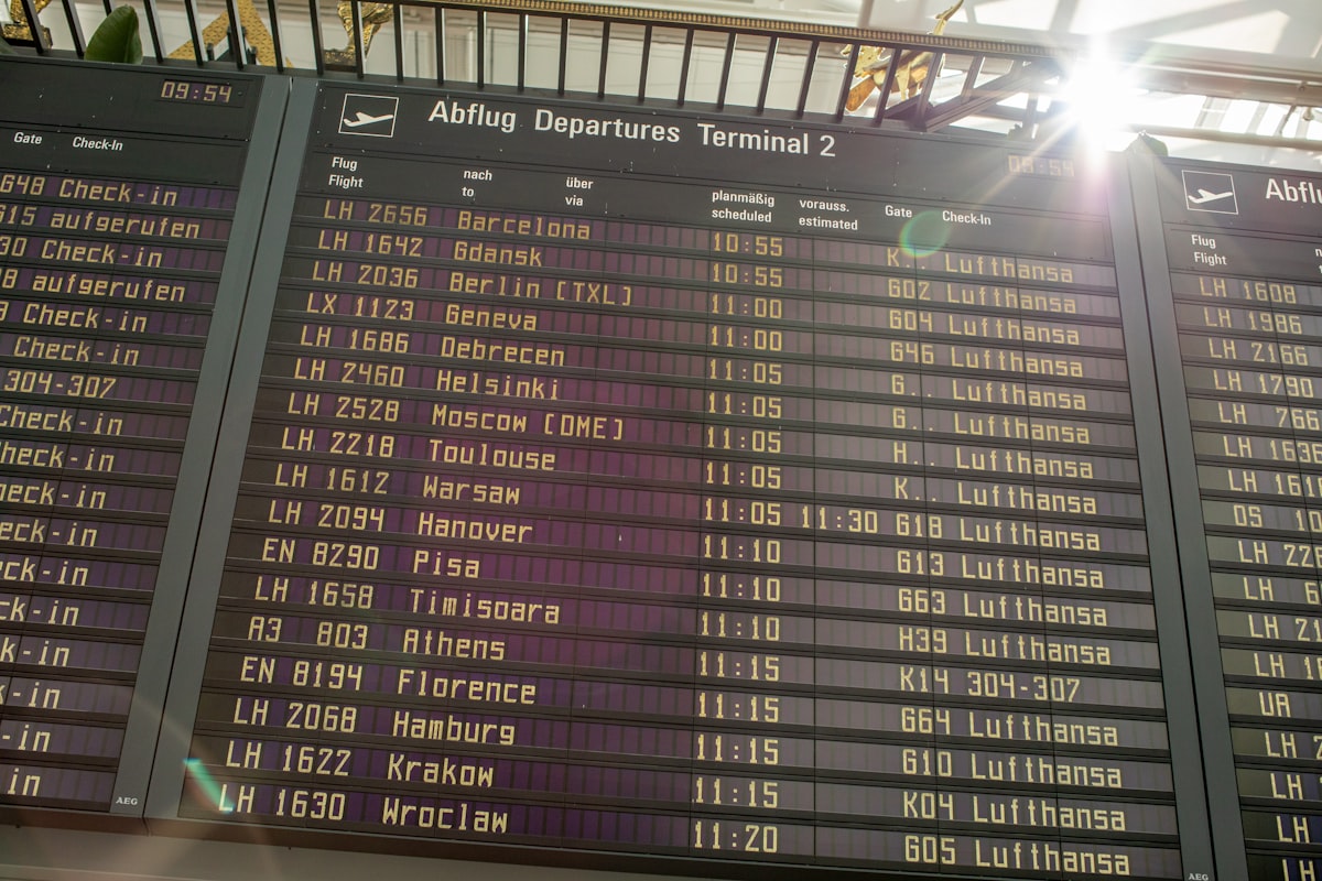 Airport departure board displaying flight information in yellow text against a dark background