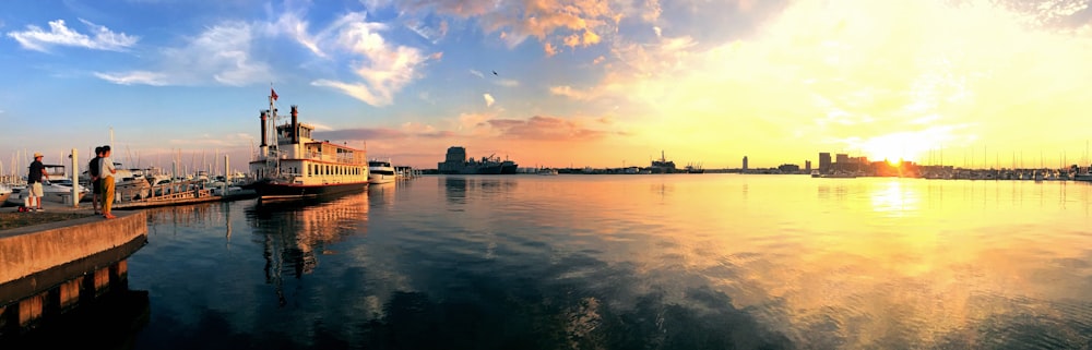 white boat in body of water during golden hour