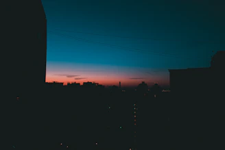 A tasteful silhouette of a woman against a city skyline at dusk, hinting at the vibrant Delhi Aerocity.