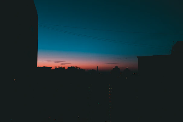 A tasteful silhouette of a woman against a city skyline at dusk, hinting at the vibrant Delhi Aerocity.