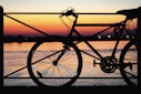 silhouette of park bicycle near body of water