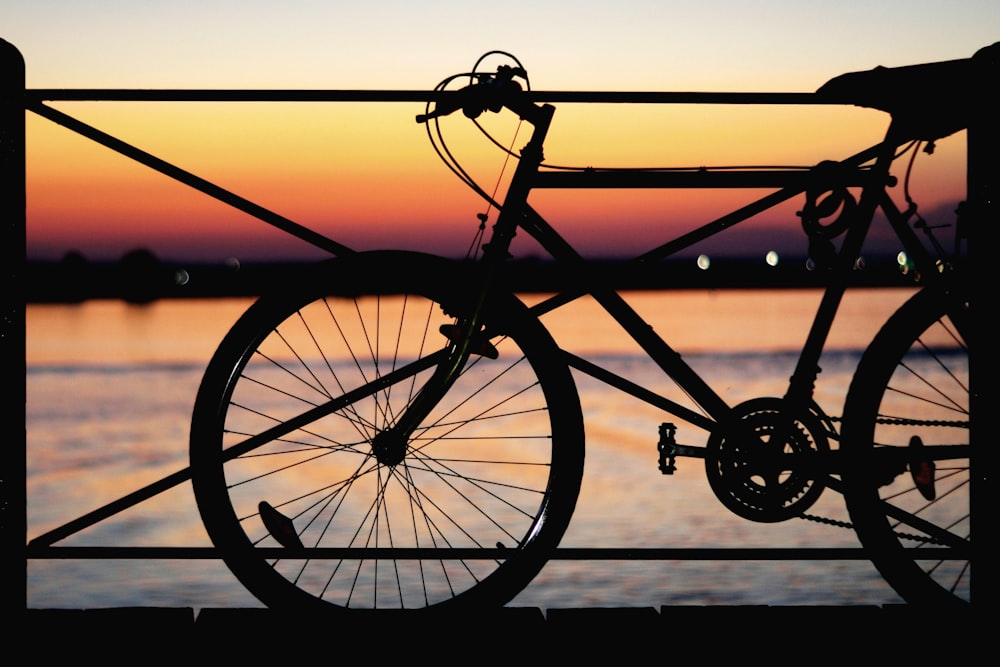 silhouette of park bicycle near body of water