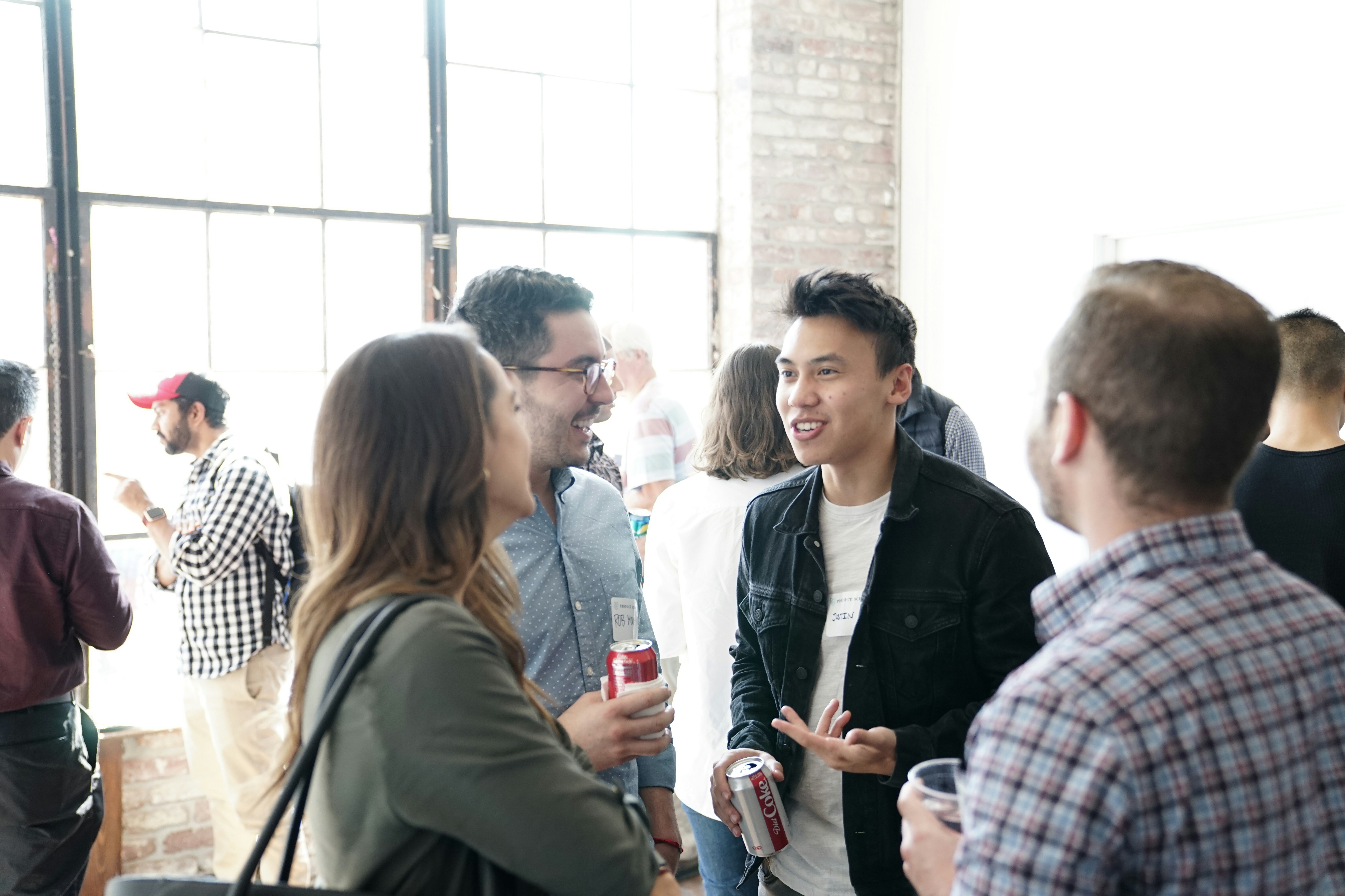 people having a conversation, talking, and smiling after an event in an open lobby