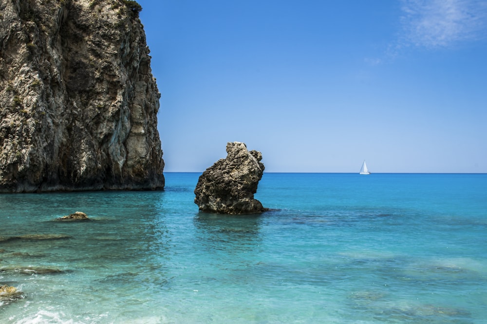 gray rock formation near body of water during daytime