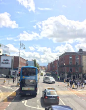 A comfortable taxi interior with a passenger enjoying a scenic Dublin street view.