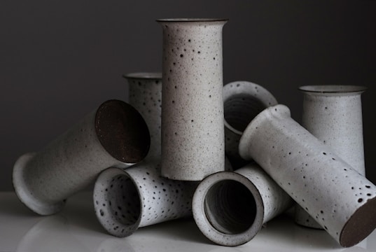A set of handmade ceramic vases with subtle textures displayed on a rustic wooden table.
