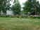 A happy homeowner admiring a freshly landscaped garden with vibrant flowers and trimmed shrubs.