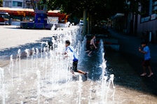 Children enjoying the water play zone with gentle fountains and shallow pools.
