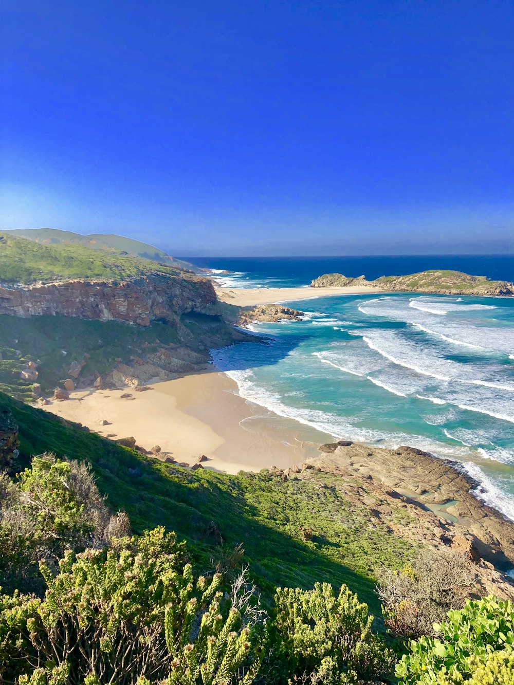 Fotografía aérea de un acantilado de montaña junto a la orilla del mar durante el día