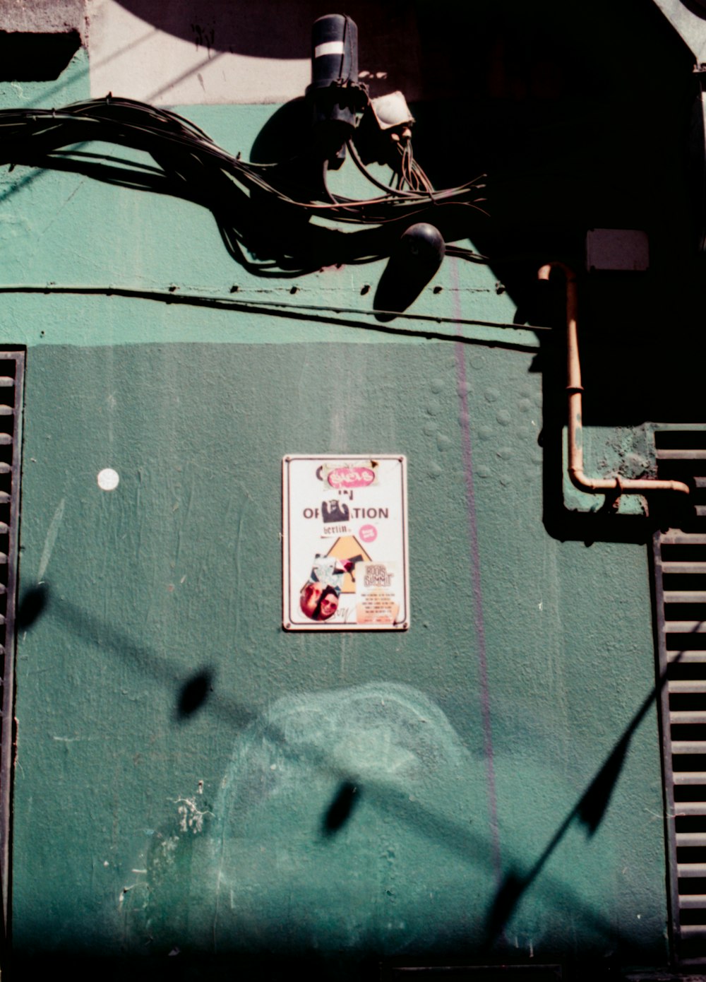 a close up of a sign on a green wall