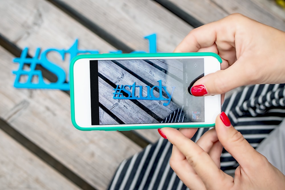 woman using white smartphone taking photo