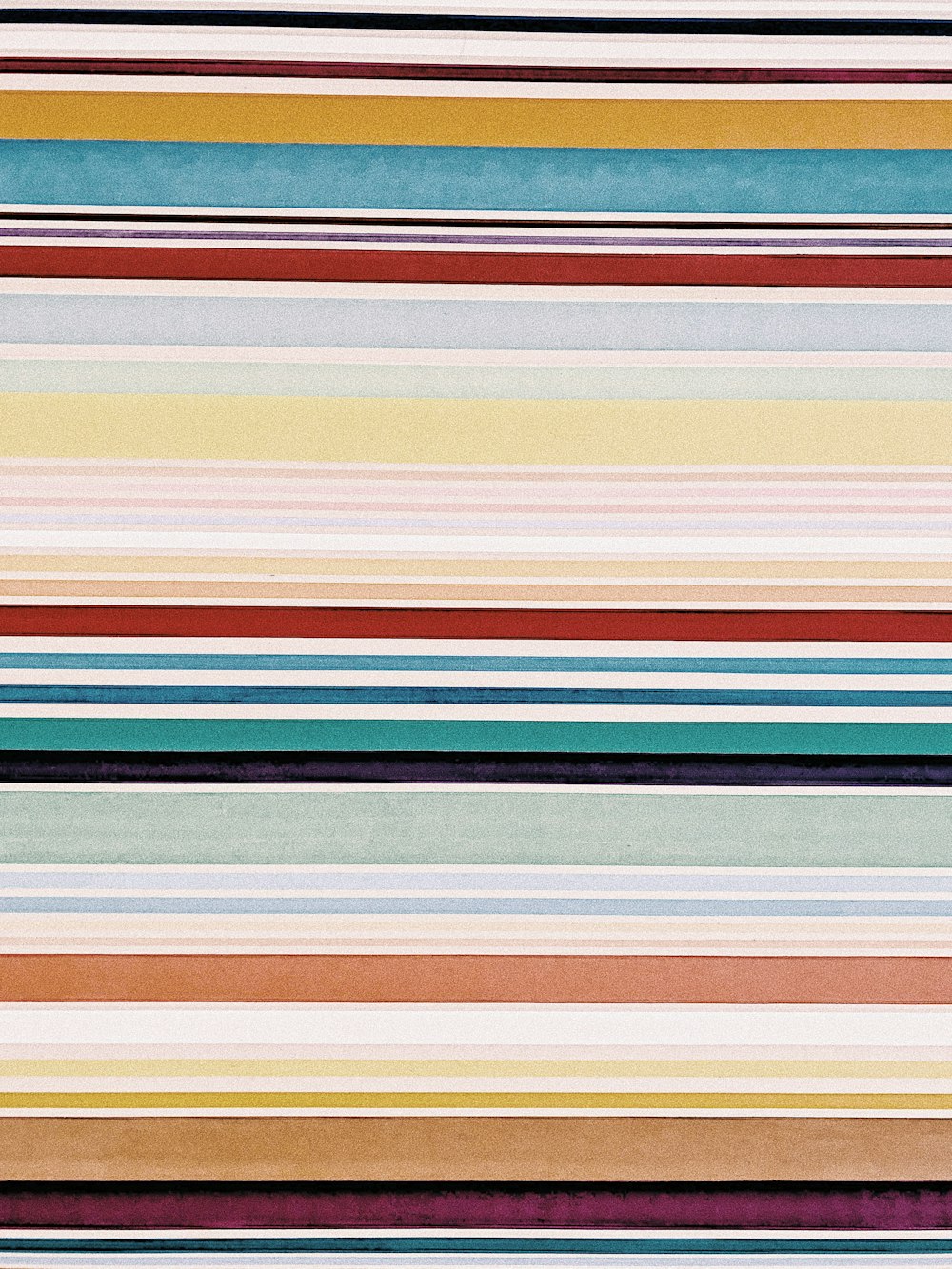 a multicolored striped wallpaper with vertical stripes