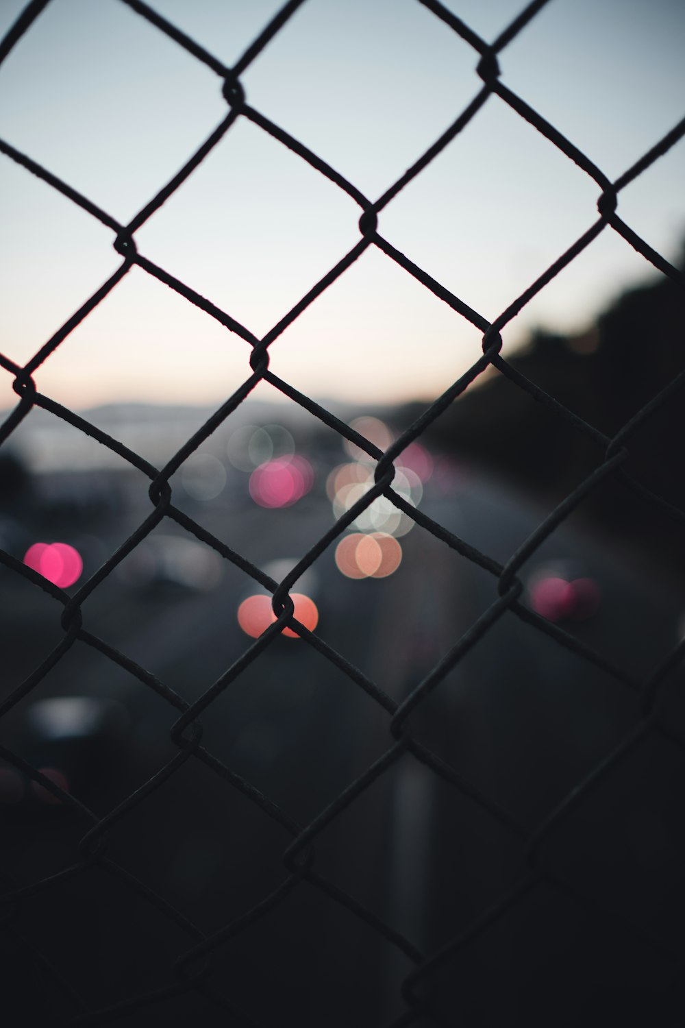 a chain link fence with a view of a city