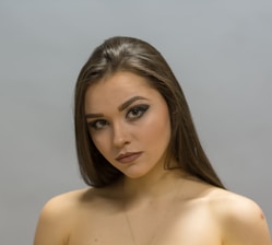 A woman smiling confidently after receiving permanent makeup on her eyebrows.