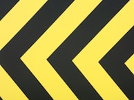a close up of a yellow and black arrow sign