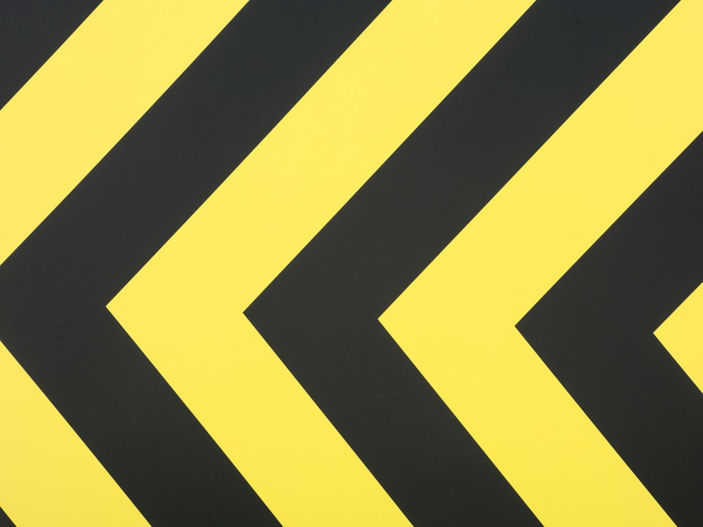 A close up of a yellow and black arrow sign photo – Free Yellow Image on  Unsplash