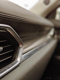 Before and after close-up of a car’s dashboard showcasing deep interior cleaning and leather conditioning.