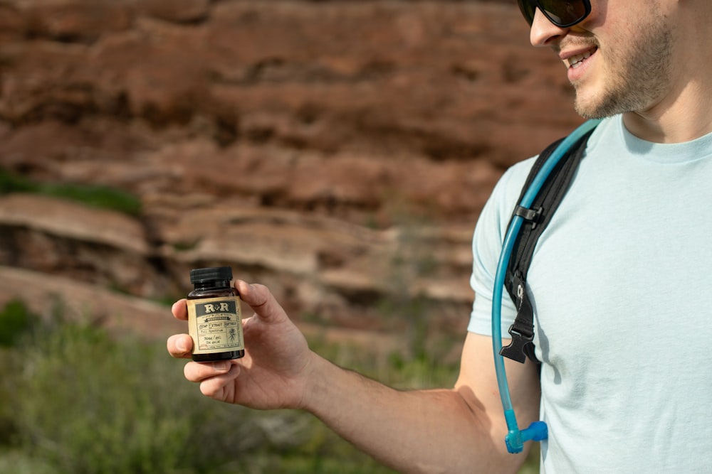 man holding brown and black RR medication jar