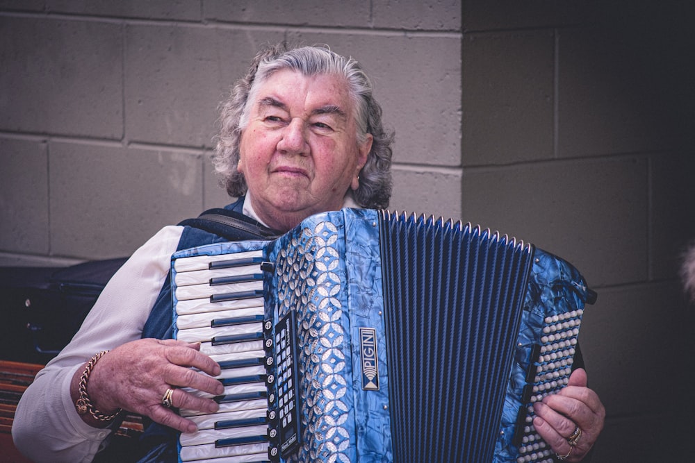 person playing blue and white accordion