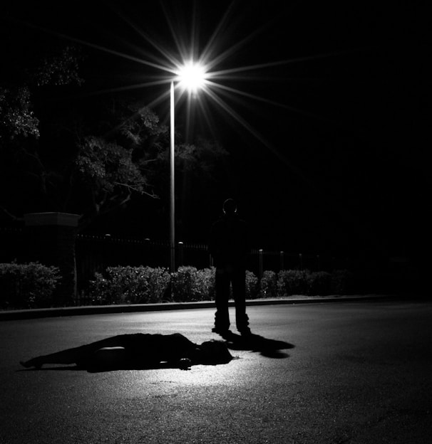 a person laying on the ground under a street light