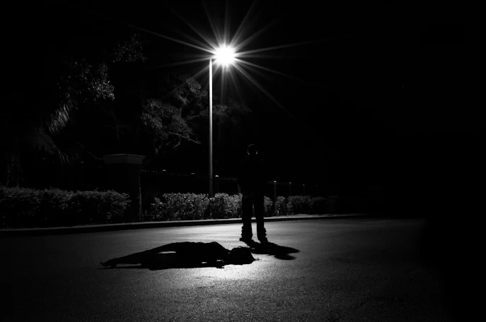 Silhouette sous un réverbère dans une rue de nuit, meilleurs podcasts true crime francophones
