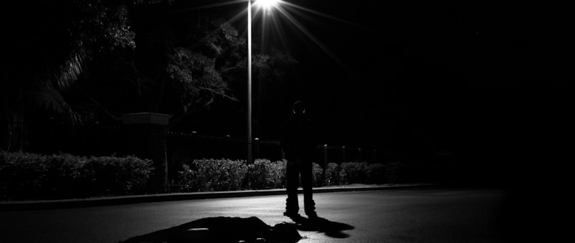a person laying on the ground under a street light
