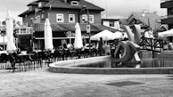 Monochrome photo capturing an open urban plaza with modern seating and landscaping.