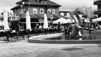 Monochrome photo capturing an open urban plaza with modern seating and landscaping.