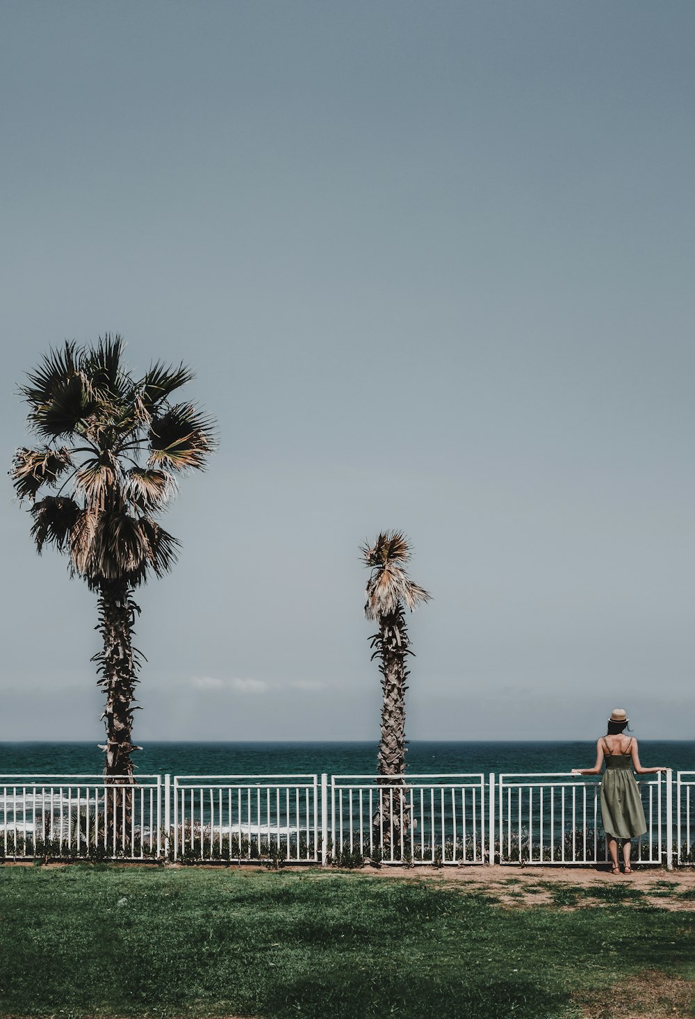 Frau steht neben Geländer an der Bucht in der Nähe von Bäumen
