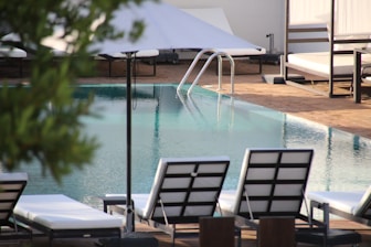 A clean poolside with neatly arranged lounge chairs inviting relaxation.