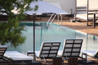 A clean and inviting swimming pool surrounded by lounge chairs.