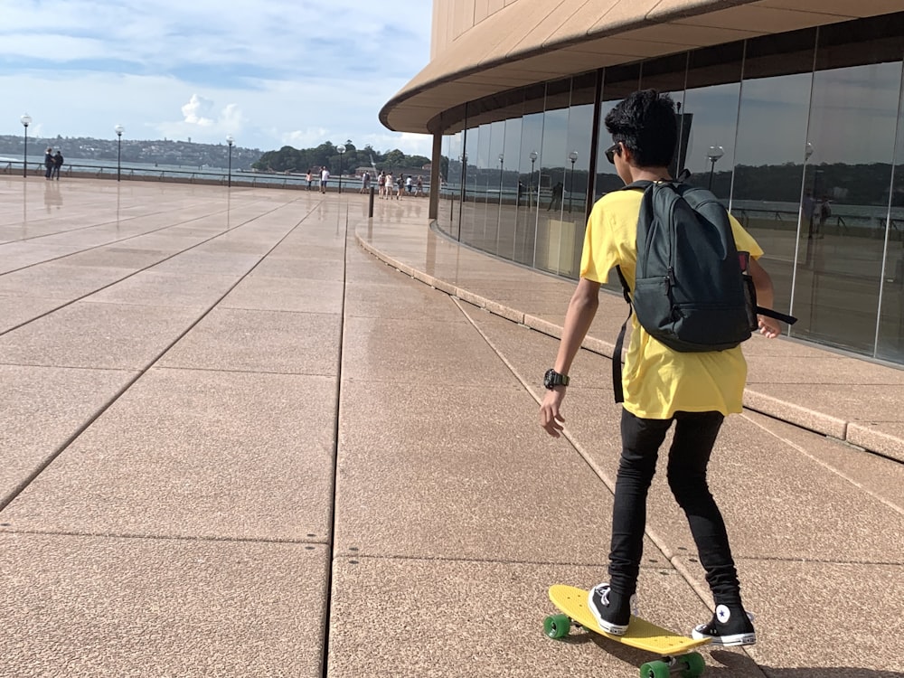 boy riding yellow skateboard during daytime