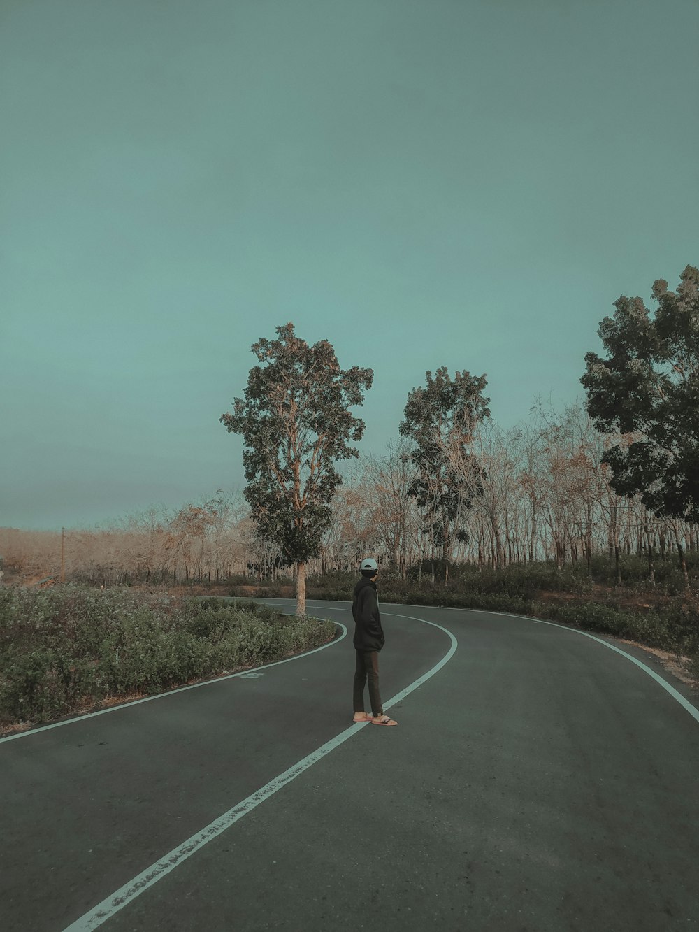 man standing on gray top road