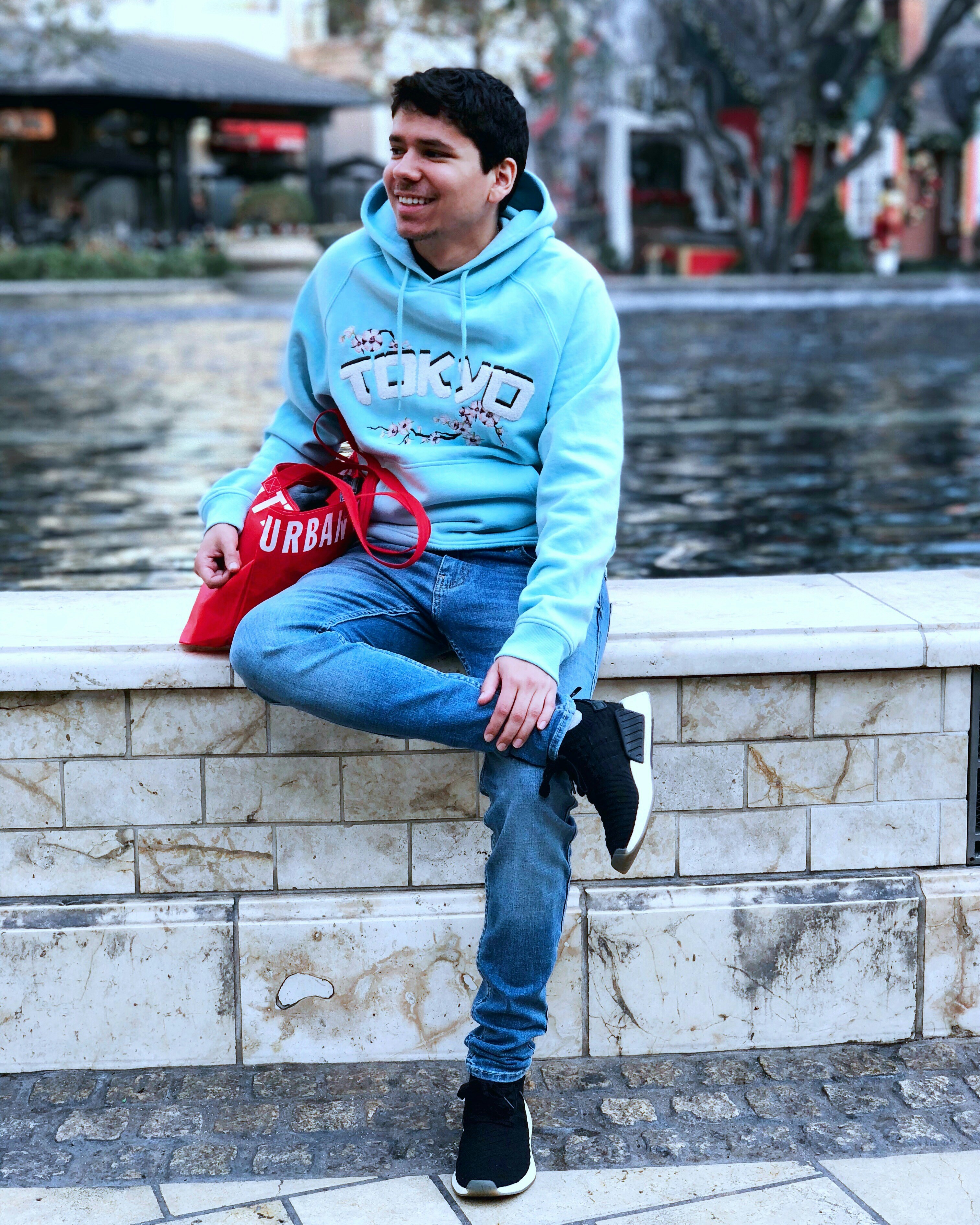 Hombre sentado en el lado de la fuente