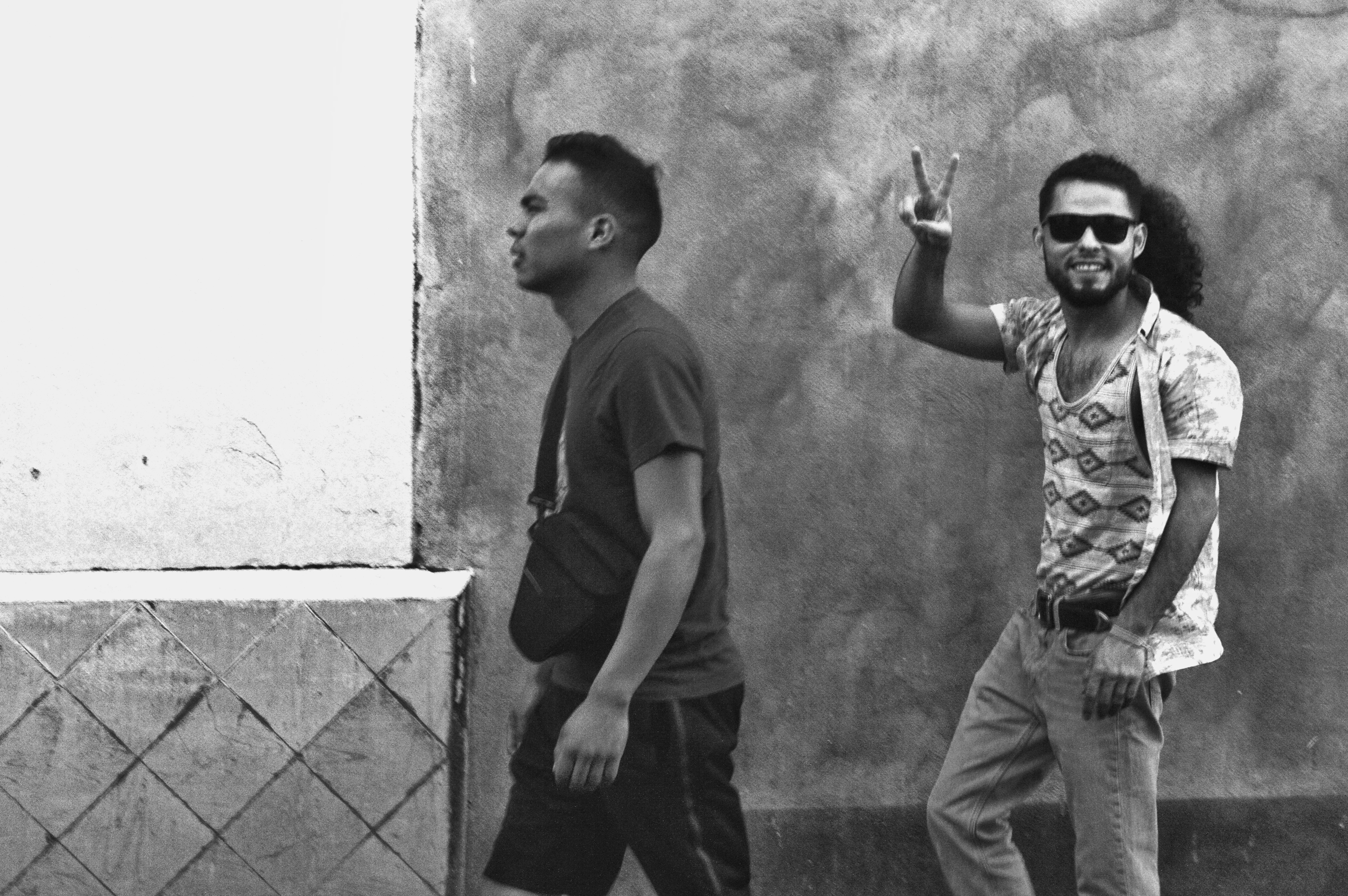 two men walking beside wall