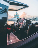 Luxury yacht cruising at sunset with sleek navy blue hull.