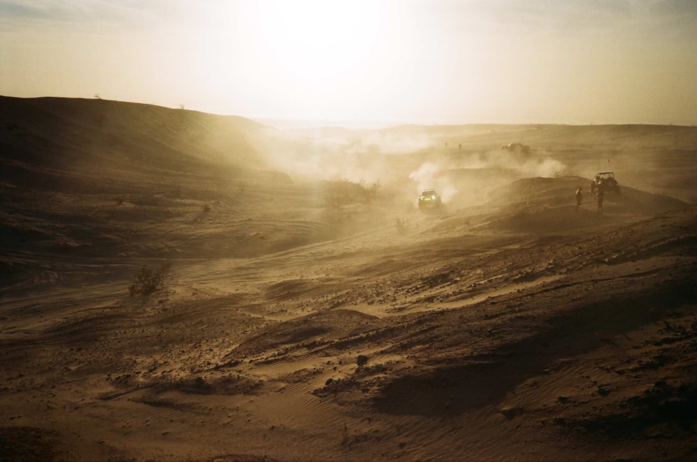 a group of trucks driving down a dirt road