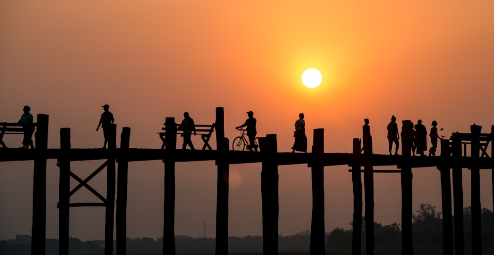 silhouette of people on bridge